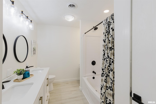 full bathroom featuring toilet, shower / bath combination with curtain, visible vents, and a sink