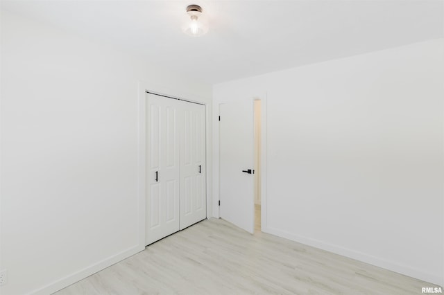 empty room featuring light wood finished floors and baseboards