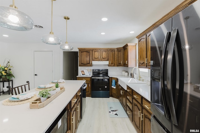 kitchen featuring light countertops, visible vents, black electric range oven, fridge with ice dispenser, and under cabinet range hood