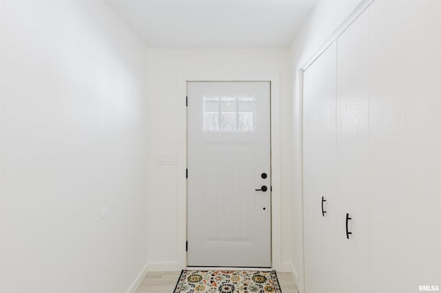 doorway to outside featuring baseboards