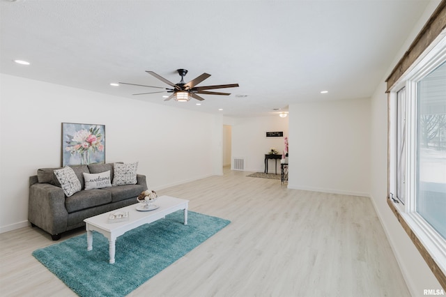 living area featuring light wood-style floors, baseboards, visible vents, and recessed lighting