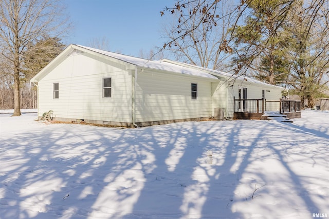 snow covered back of property featuring crawl space, cooling unit, and a wooden deck