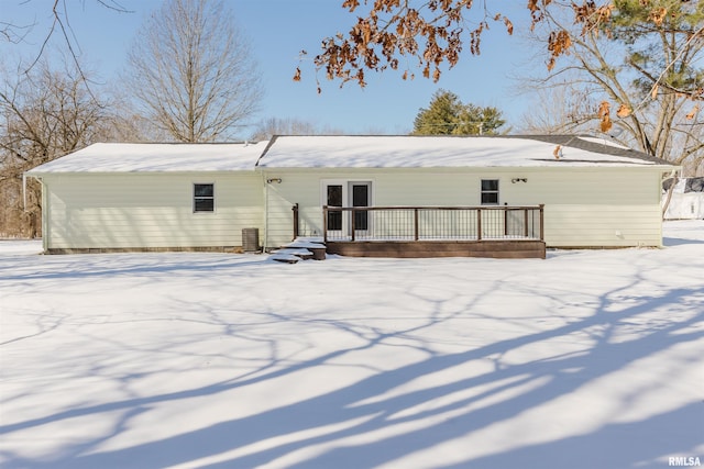 snow covered property featuring central AC unit and a wooden deck