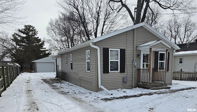 view of front of house with a garage and an outbuilding