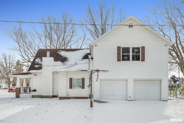 view of snowy exterior with a garage