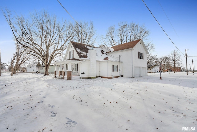 view of snowy exterior featuring a garage