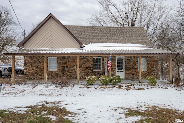 view of front of property featuring metal roof and stone siding