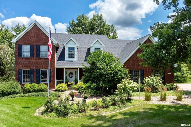 view of front of home with brick siding and a front yard