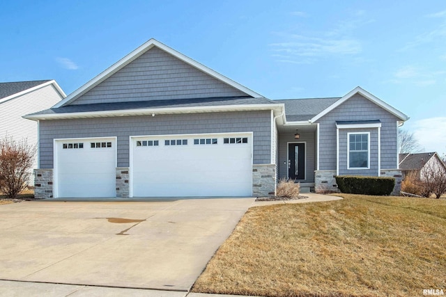 view of front of house featuring driveway, stone siding, an attached garage, and a front lawn