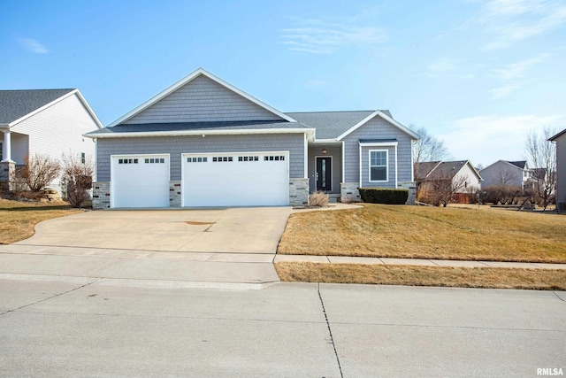 view of front of home featuring driveway, stone siding, an attached garage, and a front lawn