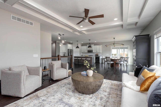 living area with visible vents, dark wood finished floors, a ceiling fan, a textured ceiling, and recessed lighting