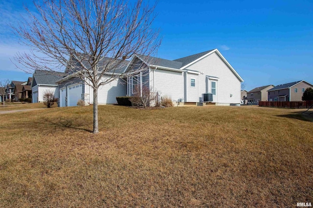 view of property exterior with a garage, a residential view, central AC, and a yard