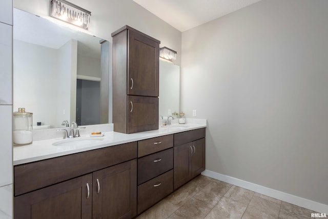 full bathroom with a sink, baseboards, and double vanity