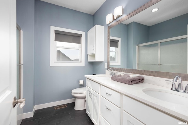 bathroom featuring visible vents, a sink, a shower stall, and toilet