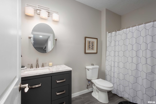 bathroom featuring baseboards, toilet, wood finished floors, curtained shower, and vanity