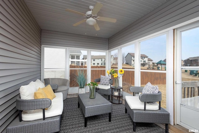 sunroom featuring a ceiling fan and a residential view