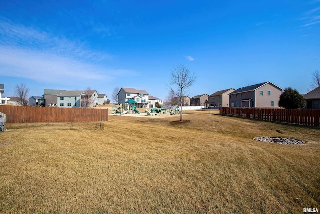 view of yard with a residential view, fence, and a playground