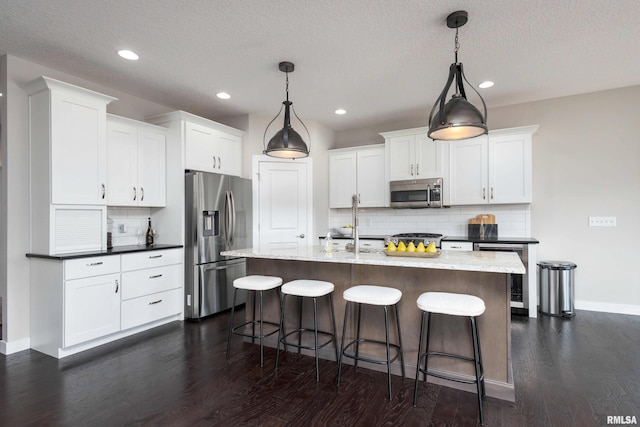 kitchen with white cabinetry, wine cooler, a kitchen bar, and appliances with stainless steel finishes