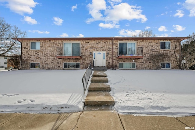 split foyer home featuring a balcony and brick siding