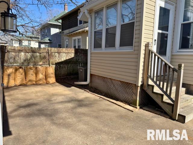 view of side of property with entry steps, a patio area, and fence