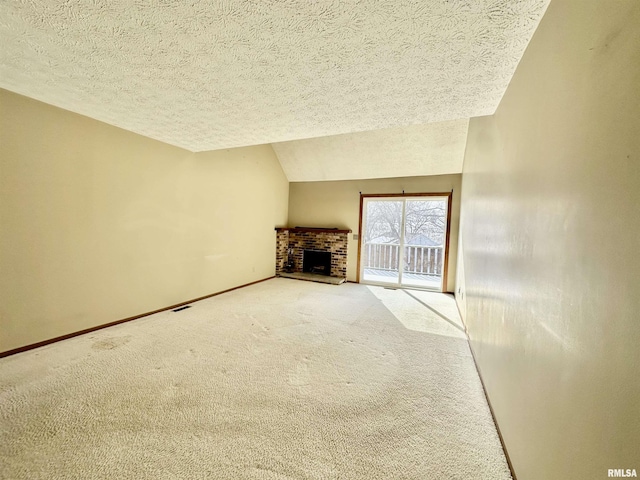 unfurnished living room featuring carpet, a textured ceiling, a brick fireplace, and lofted ceiling