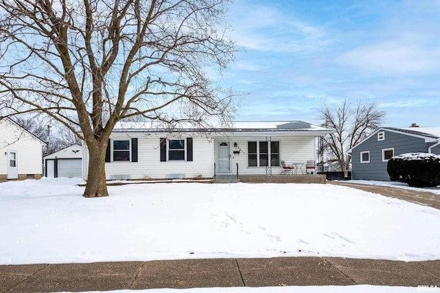 single story home with covered porch and a detached garage