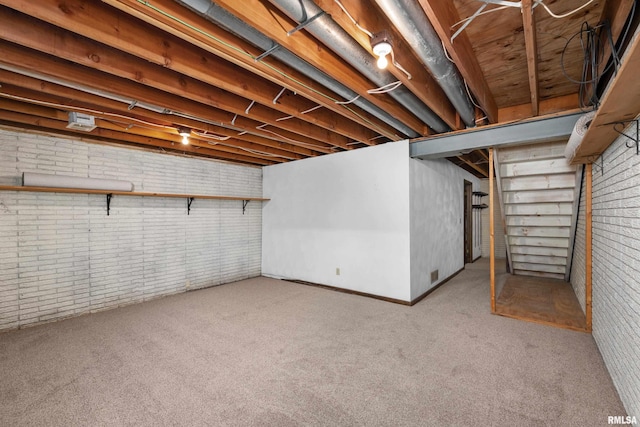 unfinished below grade area with brick wall and light colored carpet