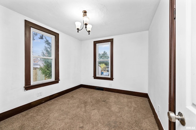 unfurnished room with dark colored carpet, visible vents, a notable chandelier, and baseboards