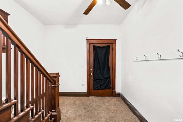 interior space with stairway, baseboards, ornamental molding, and ceiling fan