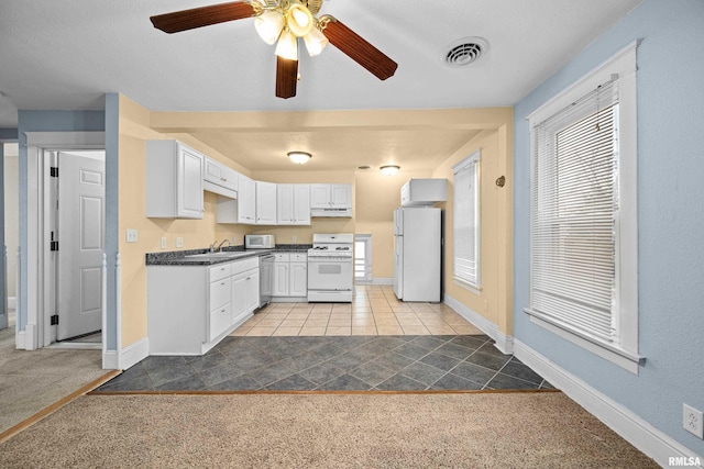 kitchen featuring dark countertops, visible vents, white cabinetry, carpet flooring, and white appliances