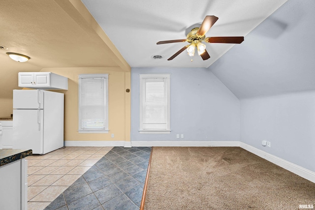 bonus room featuring visible vents, vaulted ceiling, baseboards, and light tile patterned flooring