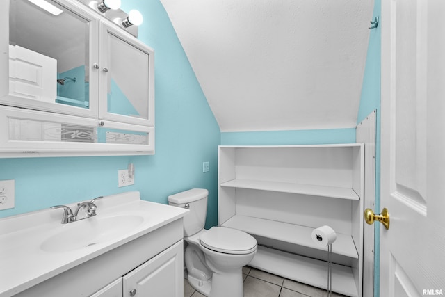 bathroom featuring toilet, vaulted ceiling, tile patterned flooring, and vanity