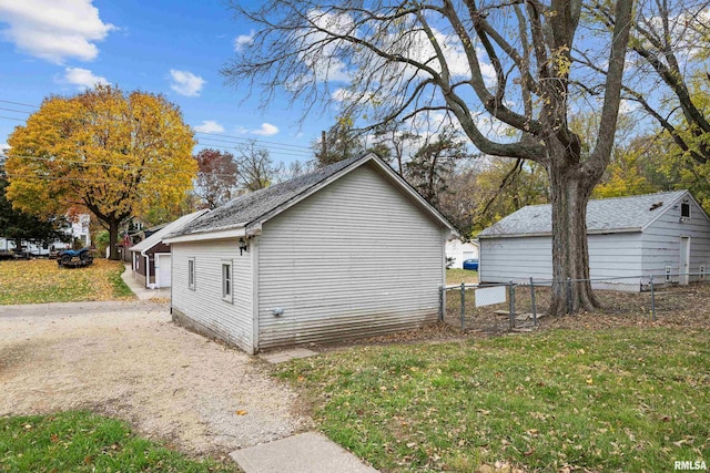 view of property exterior featuring fence and a lawn