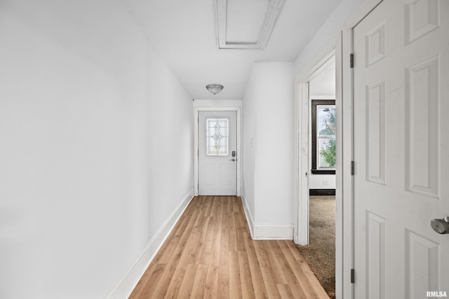 corridor featuring light wood-style flooring and baseboards