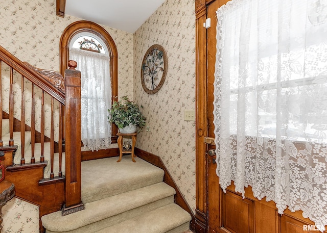 stairs featuring baseboards, wallpapered walls, and carpet floors