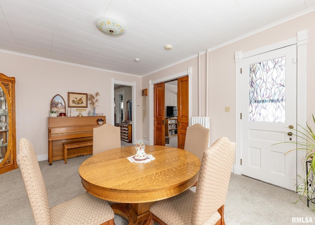 dining room with ornamental molding, light carpet, and baseboards