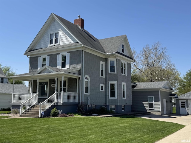view of front of house featuring a chimney, a front lawn, a porch, and a shingled roof