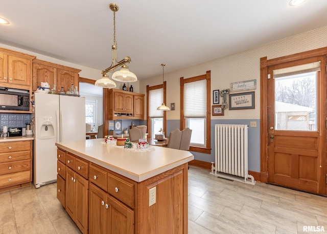 kitchen featuring radiator, white fridge with ice dispenser, black microwave, light countertops, and wallpapered walls