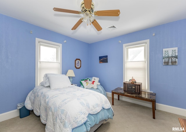 carpeted bedroom featuring a ceiling fan, visible vents, and baseboards