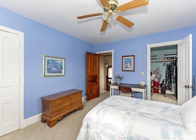 bedroom featuring light colored carpet, baseboards, a ceiling fan, and a closet
