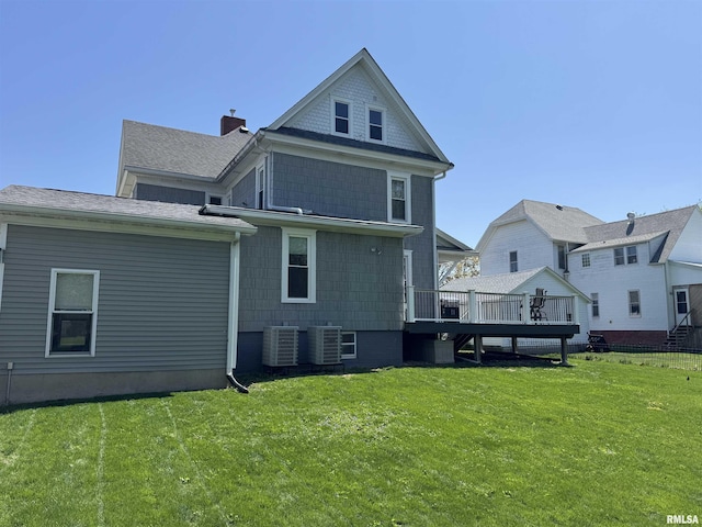 back of house featuring a lawn, central AC unit, and a wooden deck