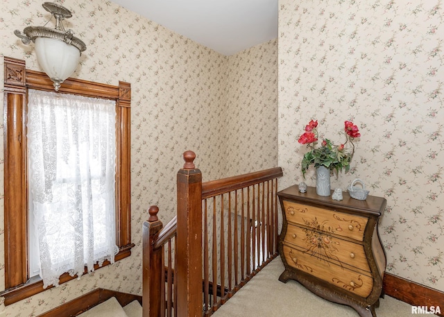 staircase featuring wallpapered walls and carpet