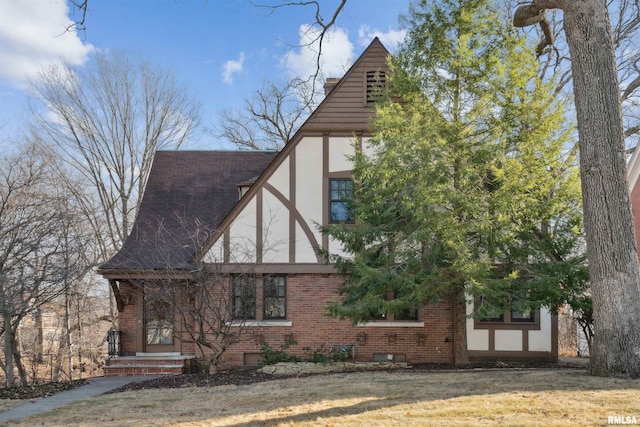 view of home's exterior featuring brick siding, a shingled roof, a yard, and stucco siding