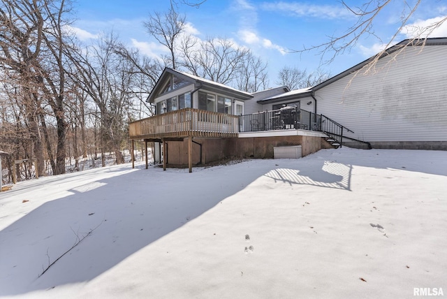 snow covered property featuring a wooden deck and stairs