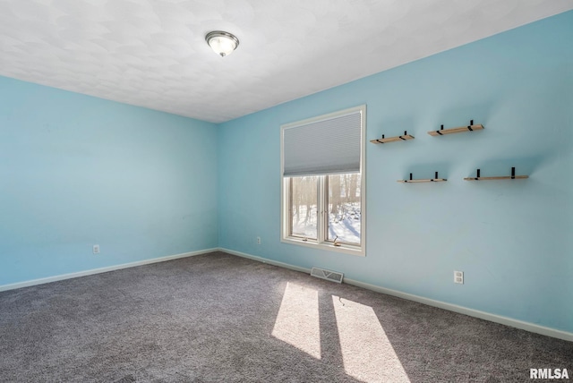 empty room featuring carpet floors, baseboards, and visible vents