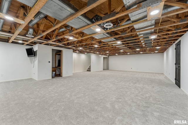 finished basement featuring carpet floors, baseboards, and stairs