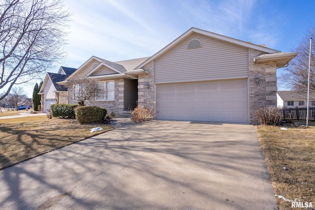 ranch-style home featuring an attached garage, stone siding, and driveway