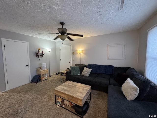 living room featuring carpet floors, visible vents, a textured ceiling, and a ceiling fan