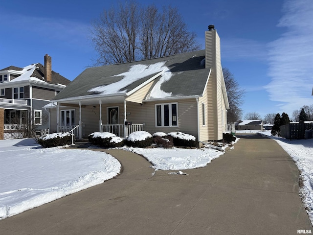 view of front facade with covered porch and a chimney