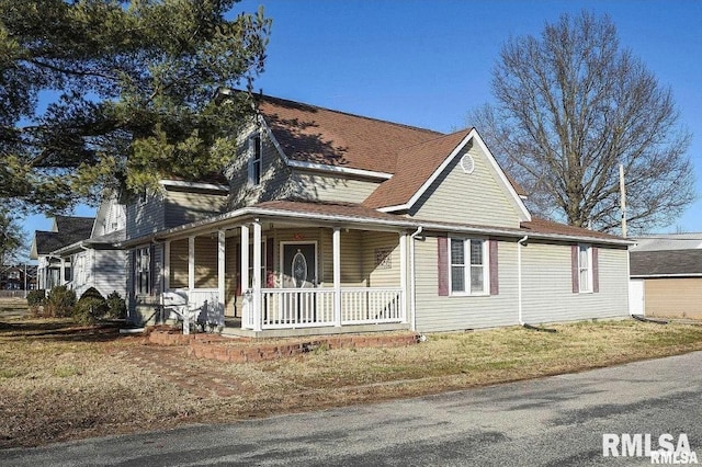 view of front of property featuring crawl space, a front lawn, a porch, and roof with shingles